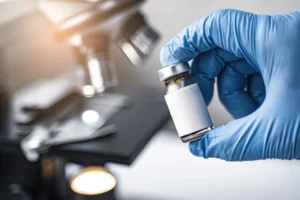 Vaccine vial, medical glove, research, COVID-19 vaccine