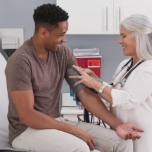 doctor holding a smiling patient's arm and testing his blood pressure
